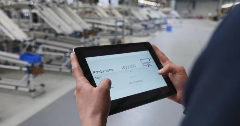 Line operator engaged in real-time monitoring and control of the assembly line through the supervision software Movin ActionHub, managed via tablet