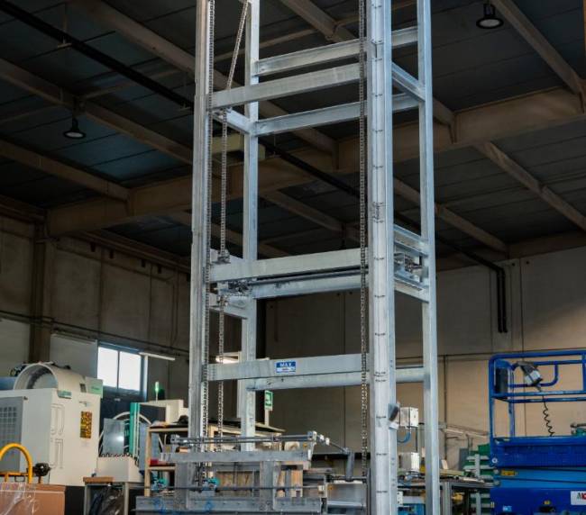 Industrial tilter designed to invert totes and pour powders into the mixer during the powder blending process
