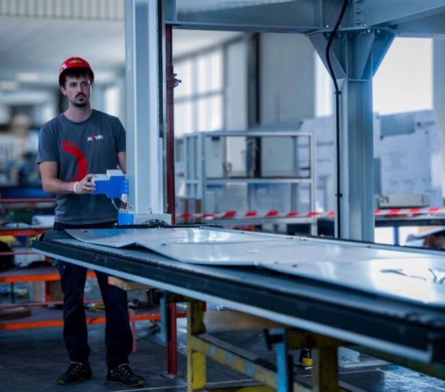 Movin mechatronic specialist commissioning a semi-automatic manipulator system for foam sandwich panel handling along the commercial refrigeration cabinet assembly line