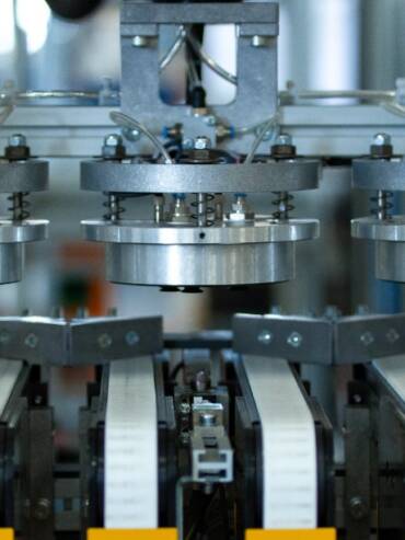 Robotic vacuum gripper picking circular blades from the transfer conveyors during the painting and screen-printing process