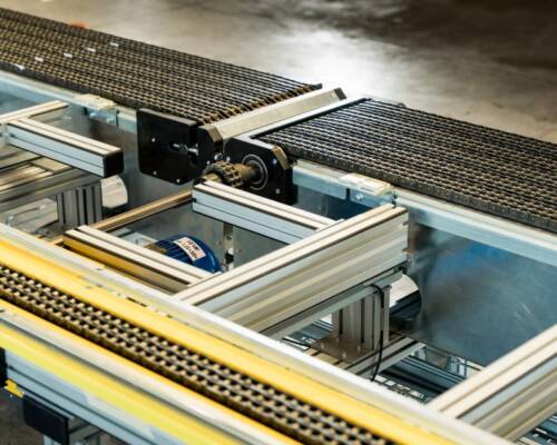 Chain conveyor handling commercial display cabinets of varying sizes along the Movin assembly line