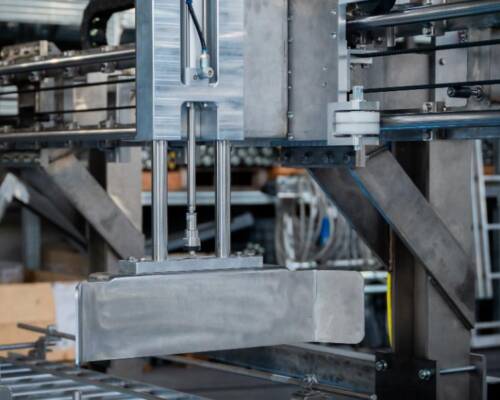 Electric pusher designed by Movin to transfer totes between motorized roller conveyors in an ATEX-rated zone