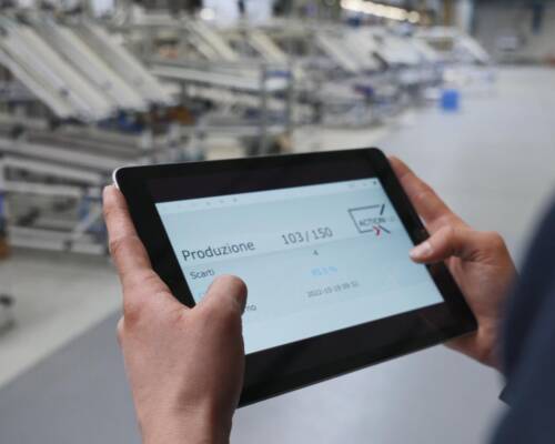 Line operator engaged in real-time monitoring and control of the assembly line through the supervision software Movin ActionHub, managed via tablet