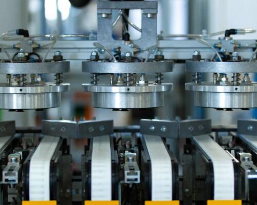 Robotic vacuum gripper picking circular blades from the transfer conveyors during the painting and screen-printing process