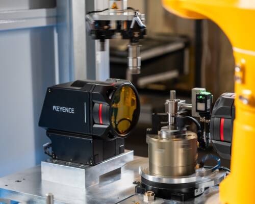 Movin inspection cell performing dimensional and surface checks on a part at end-of-process using machine vision and an industrial robot